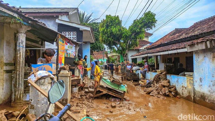 1761650031194-warga-kampung-tugu-saling-membantu-mengevakuasi-motor-dan-perabot-rumah-tangga-yang-rusak-akibat-terendam-lumpur-banyak-warga--1761628876736_169