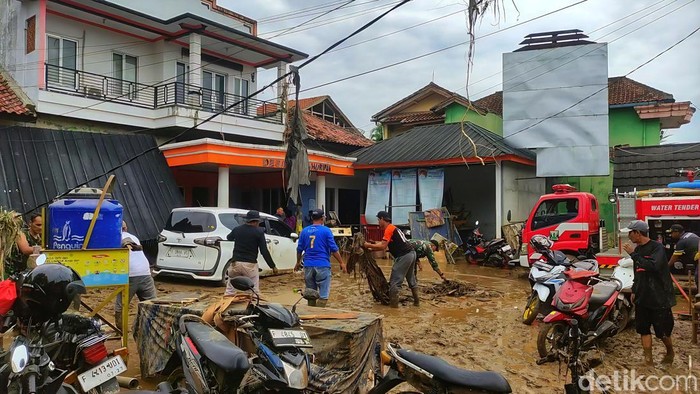 1761650112022-warga-kampung-tugu-saling-membantu-mengevakuasi-motor-dan-perabot-rumah-tangga-yang-rusak-akibat-terendam-lumpur-banyak-warga--1761628876812_169