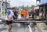 1762341384660-warga-dan-petugas-gabungan-membantu-evakuasi-sepeda-motor-yang-tertimpa-tiang-1762336142162_169