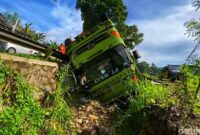 1763356377630-truk-pengangkut-batubara-terjungkir-ke-selokan-di-jalur-cibadak-warungkiara-senin-17112025-warga-membantu-proses-evakuasi-sopi-1763350596388_169