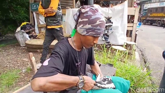 1765818270486-sulaeman-tukang-sol-sepatu-tetap-bekerja-saat-bangunan-di-pinggir-sungai-sukalila-dibongkar-1765785029510_169